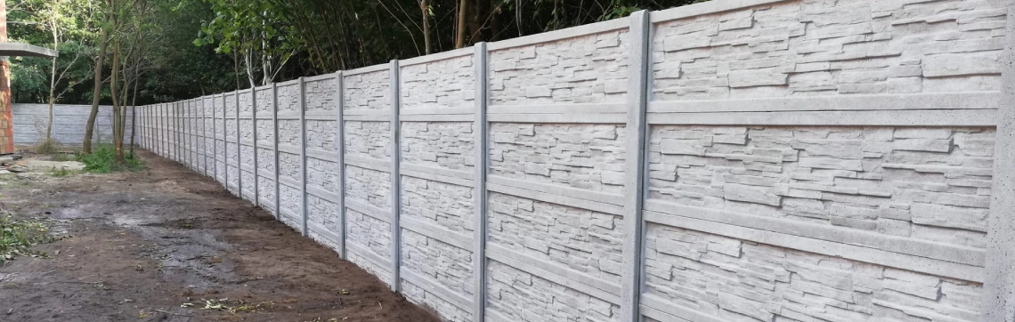 Długie, pełne ogrodzenie betonowe
